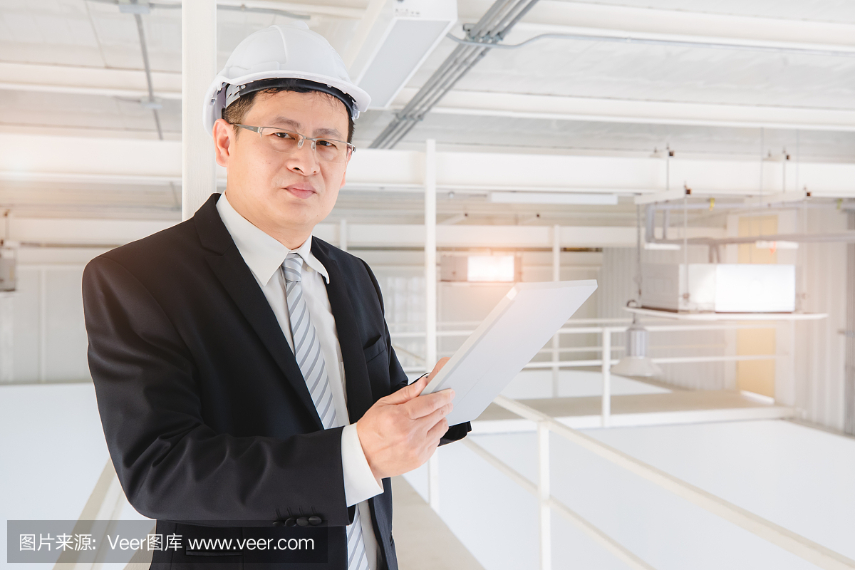 亚洲工程师在工业工厂使用平板电脑。